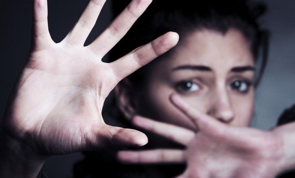 Woman shielding her face with her hands