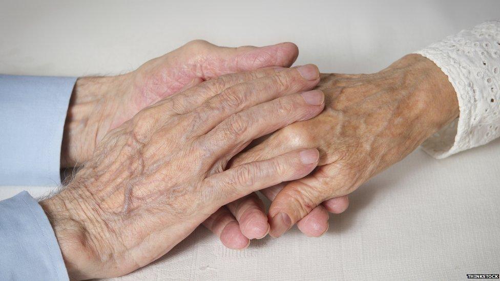 elderly couple holding hands