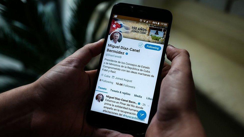 A person holds a smartphone showing the twitter account of Cuban President Miguel Diaz-Canel, in Havana, on October 10, 2018