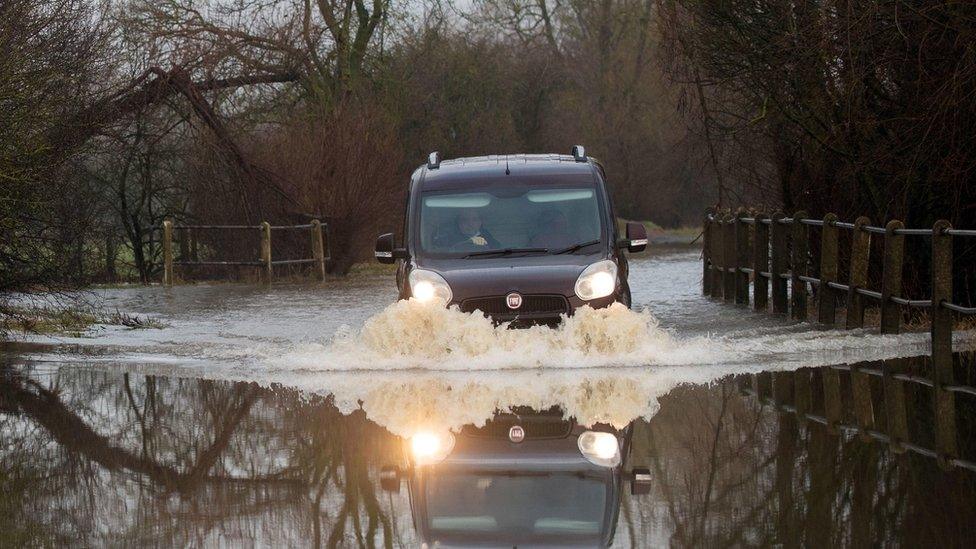 A car makes its way along a flooded road in Mountsorrel, Leicestershire