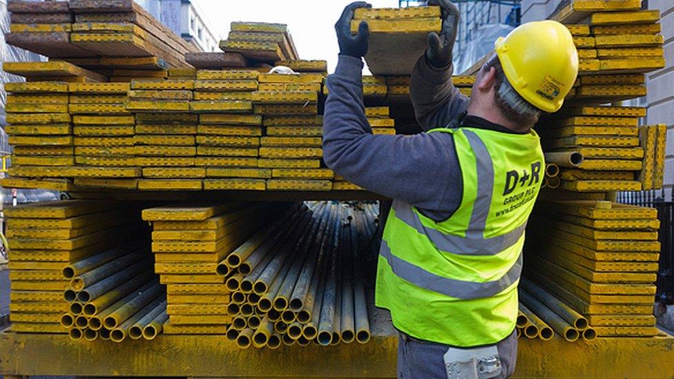 Construction site workman lifts out scaffolding