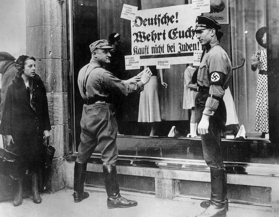 1st April 1933: Members of the SA and SS in Berlin, pasting a notice onto a Jewish business, urging Germans to boycott Jewish shops