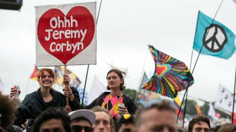 A woman holds a placard reading 'Ohhh Jeremy Corbyn'