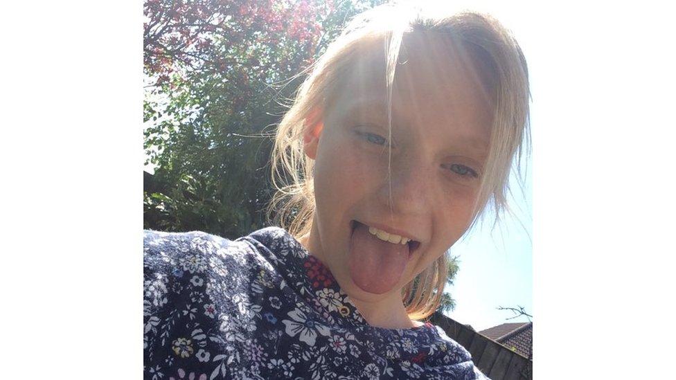 Girl poses for selfie with tongue sticking out.