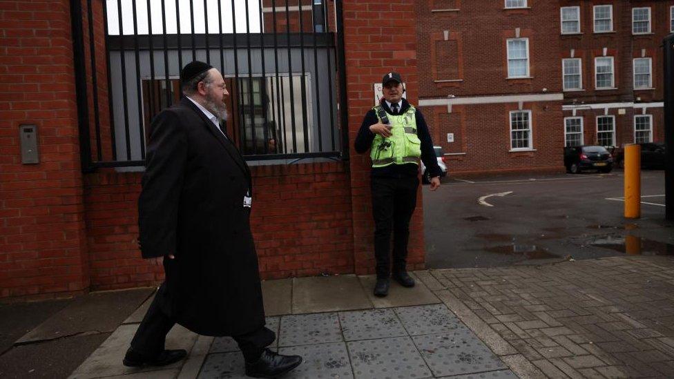 A security guard outside a Jewish school