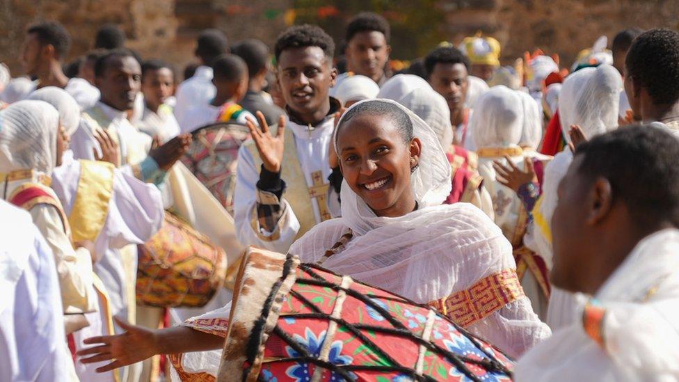 A woman banging a drum