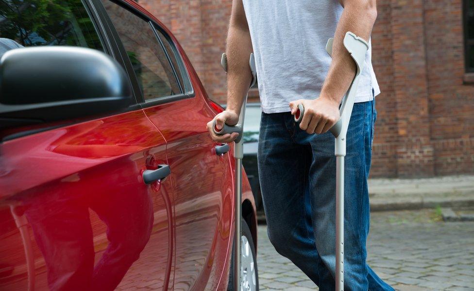 Disabled man opening door of a car