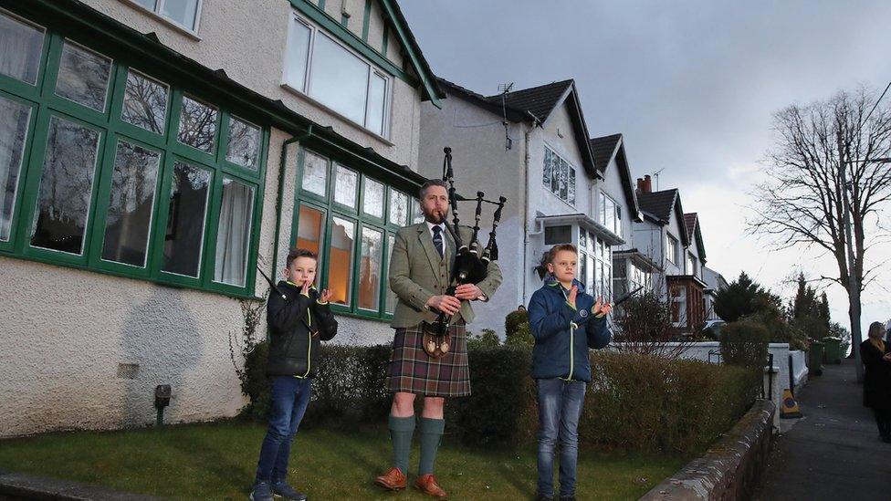 Finlay MacDonald plays the pipes at his home in Glasgow