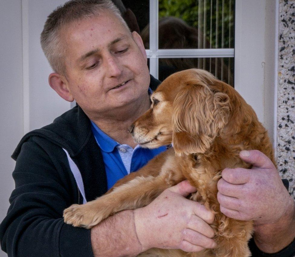 Steven Gallagher holds his dog