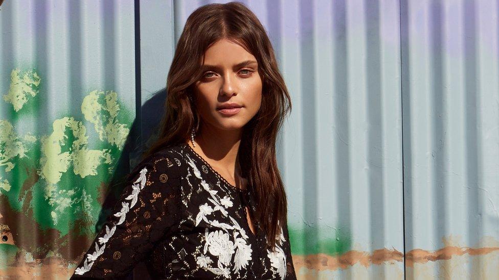 Woman in front of fence