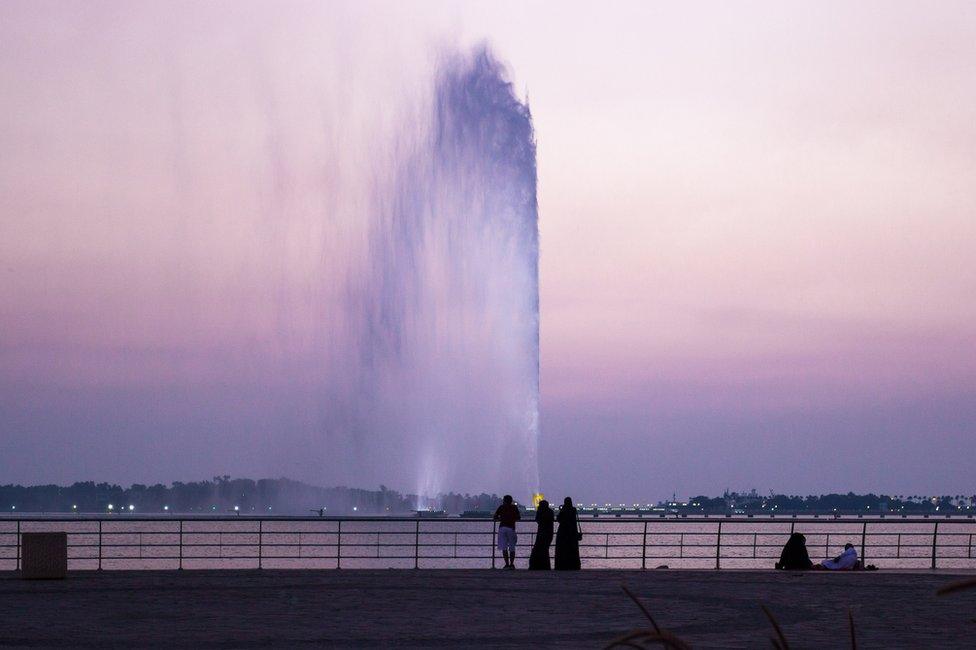 People looking at King Fahd's Fountain as the sun sets