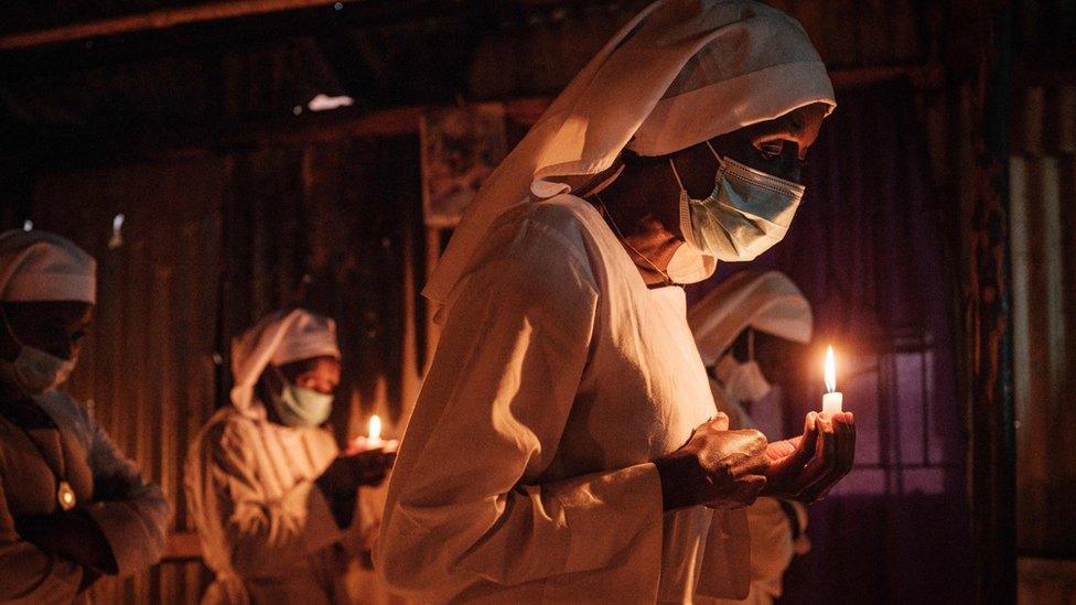 Worshippers of Legio Maria wearing face mask as a preventive measure against the spread of COVID-19 attend the Christmas prayer at their church in the Kibera slum of Nairobi, on December 25, 2020.