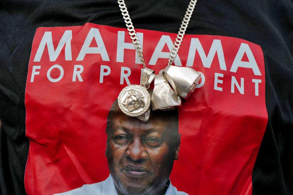 A close-up of a T-shirt worn by a supporter of Ghana’s National Democratic Congress (NDC) in Accra with a photo of John Mahama over which is a large gold necklace - Monday 9 December 2024