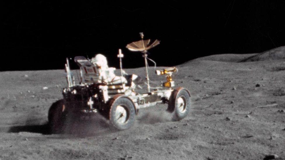 Astronaut John Young drives the lunar rover