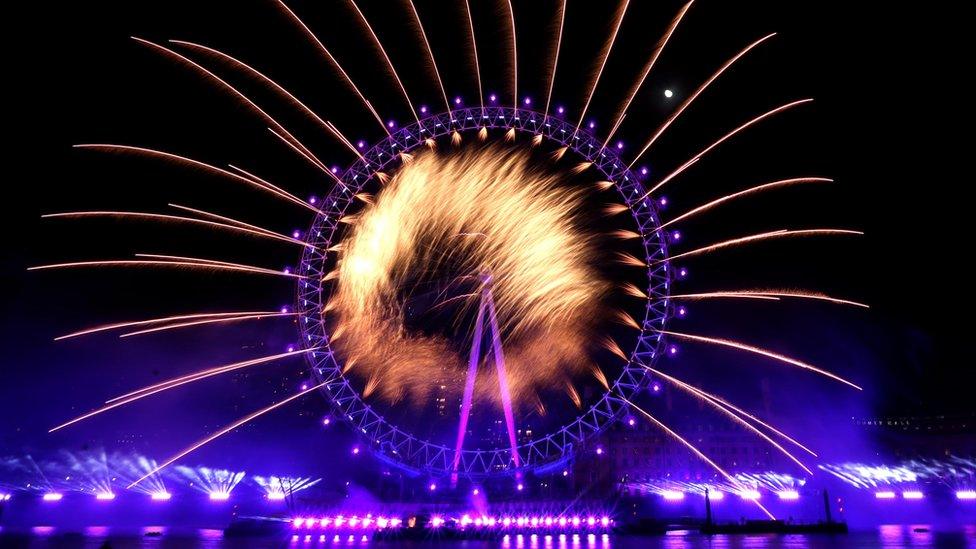 The London Eye is lit up by fireworks