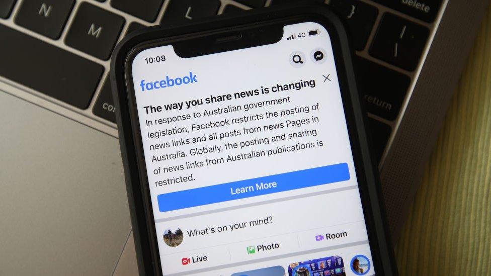 In this photo illustration a message is seen on Facebook mobile about changes on sharing of news