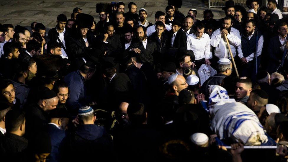 Family and friends of Eli and Natali Mizrahi carry their bodies during their funeral