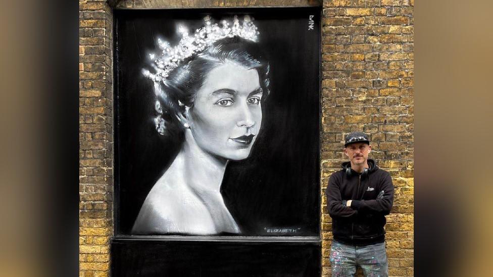 Dan Kitchener standing next to his street art tribute to Queen Elizabeth II