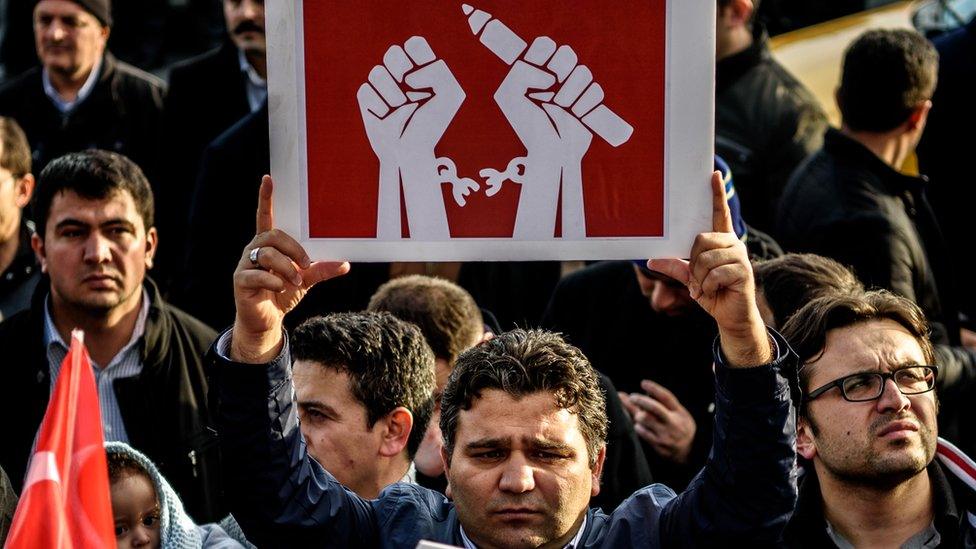 A man holds up a placard as people demonstrate in support of Turkish daily newspaper Zaman in Istanbul on 4 March 2016