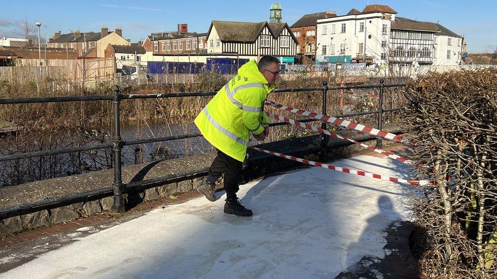 Person cordoning vandalised walkway