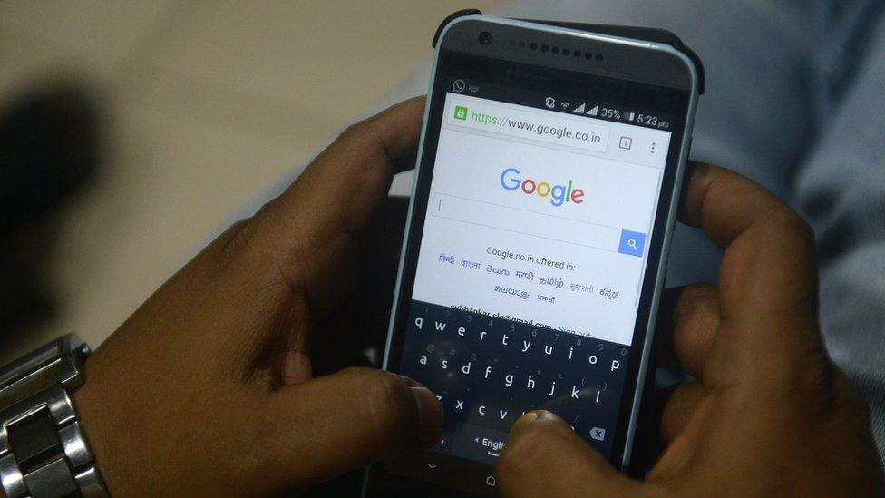 An Indian man using Google search on his mobile