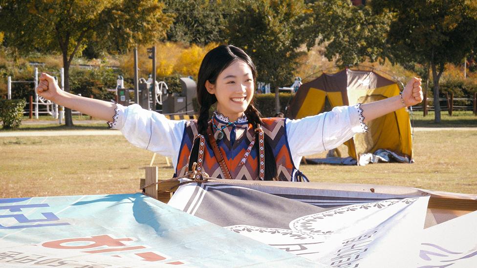 Strong Girl Nam-soon sitting under a home-made yurt in a park in Seoul