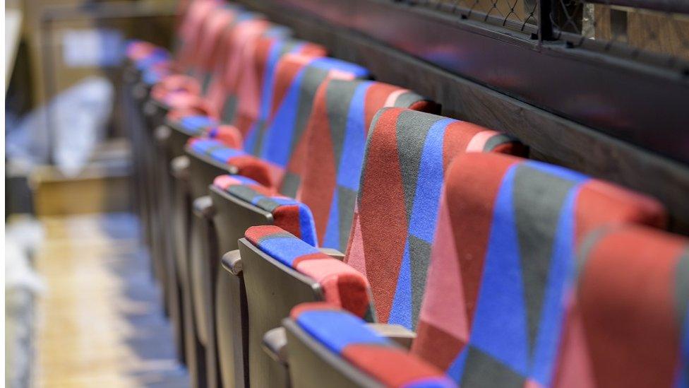 Fold-down theatre seats in red and blue.