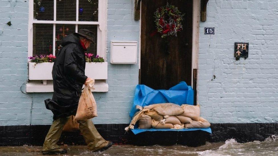 sandbags being placed on a doorstep as water splashes below