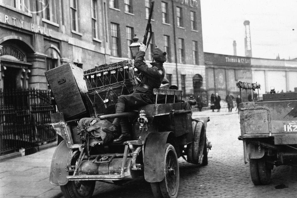 A Black and Tan soldier on a vehicle piled with commandeered property during a raid on Dublin's Liberty Hall