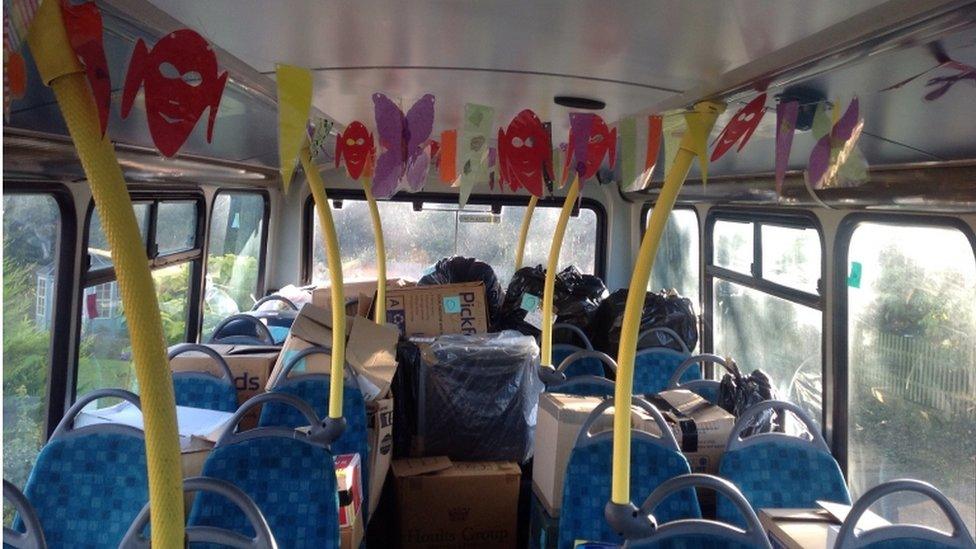 Boxes and bunting on the upper deck of the bus