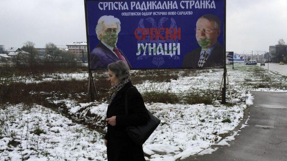 A woman walks past a poster of Radovan Karadzic (left) and leader of Crb Radical Party Vojislav Seselj, with the text reading in Cyrillic "Serbian heroes", in the Bosnian Serb part of Sarajevo. Photo: 24 March 2016