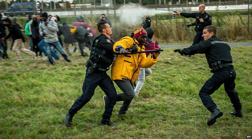 French police drive off migrants seeking to enter the Eurotunnel site in Calais