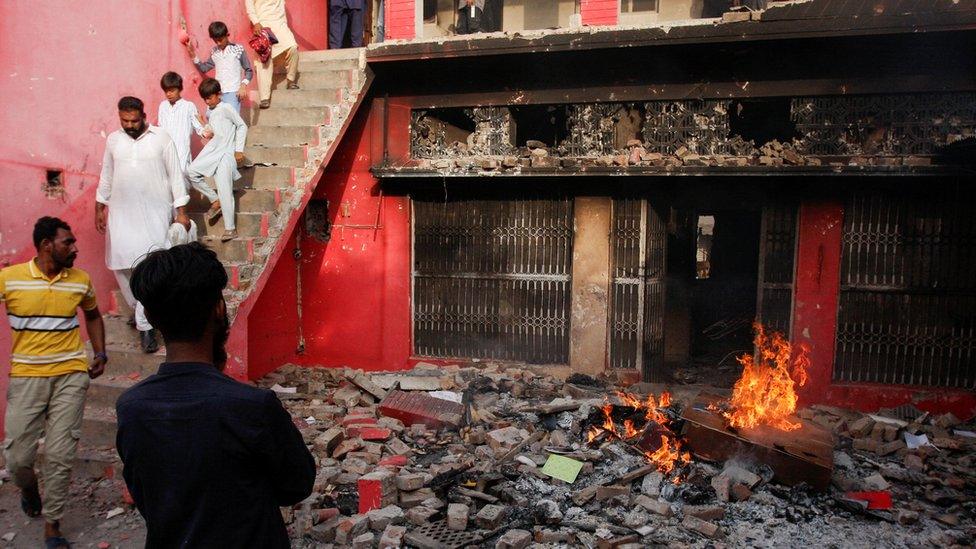 People gather at a church building vandalized by protesters in Jaranwala, Pakistan August 16, 2023