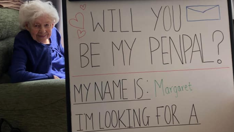 Margaret with a sign asking for a penpal who loves travelling