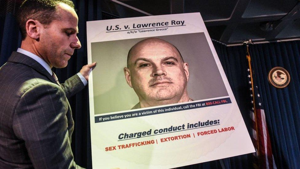 Photo of FBI poster for Lawrence Roy at a 2020 press conference where charges against him were announced.