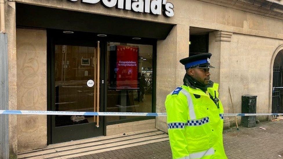 Police officer standing in front of cordoned area