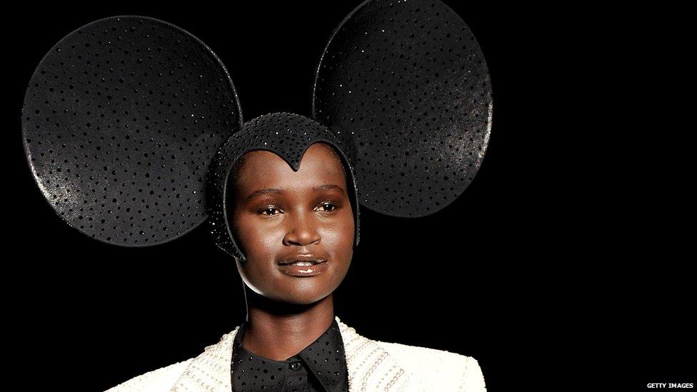 Model wearing hat resembling mouse ears.