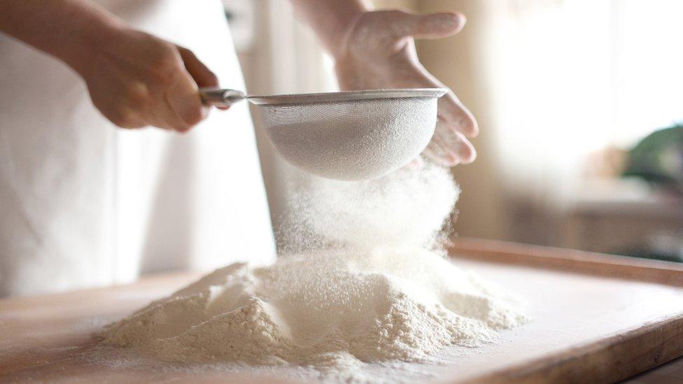 Person sifting flour