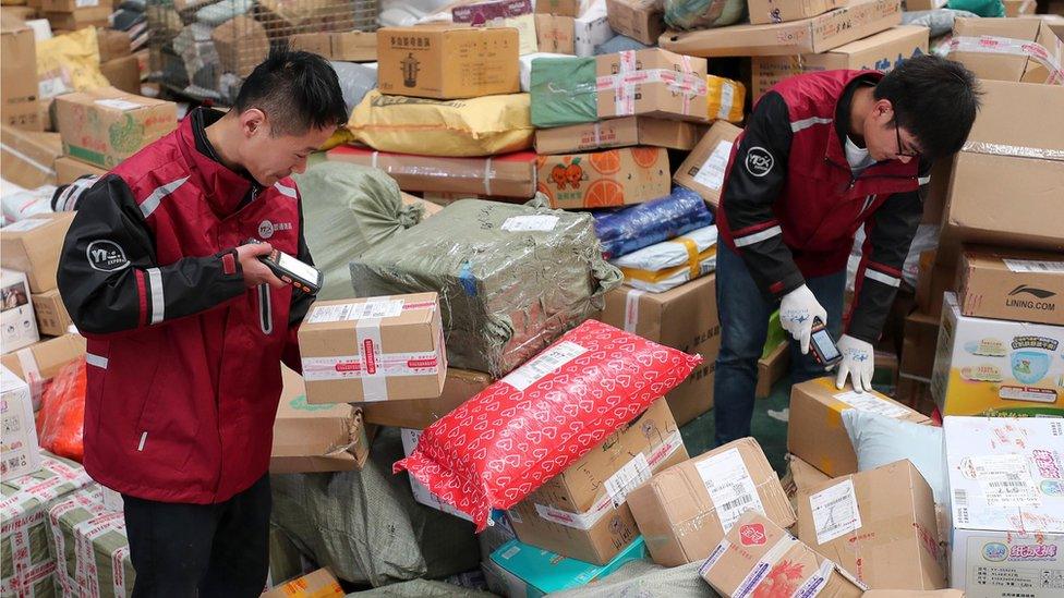 Workers scanning parcels in distribution centre