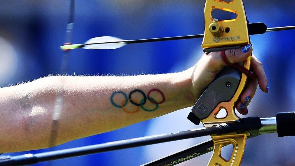 A tattoo of the Olympic rings is seen on the forearm of Sweden's Christine Bjerendal as she shoots an arrow during the Rio 2016 Olympic Games women's competition at the Sambodromo archery venue in Rio de Janeiro, Brazil, on August 9, 2016