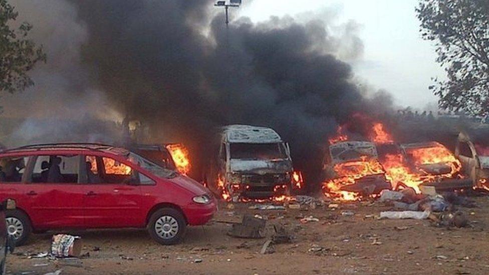 Vehicles burn after an attack in Abuja on 14 April 2014