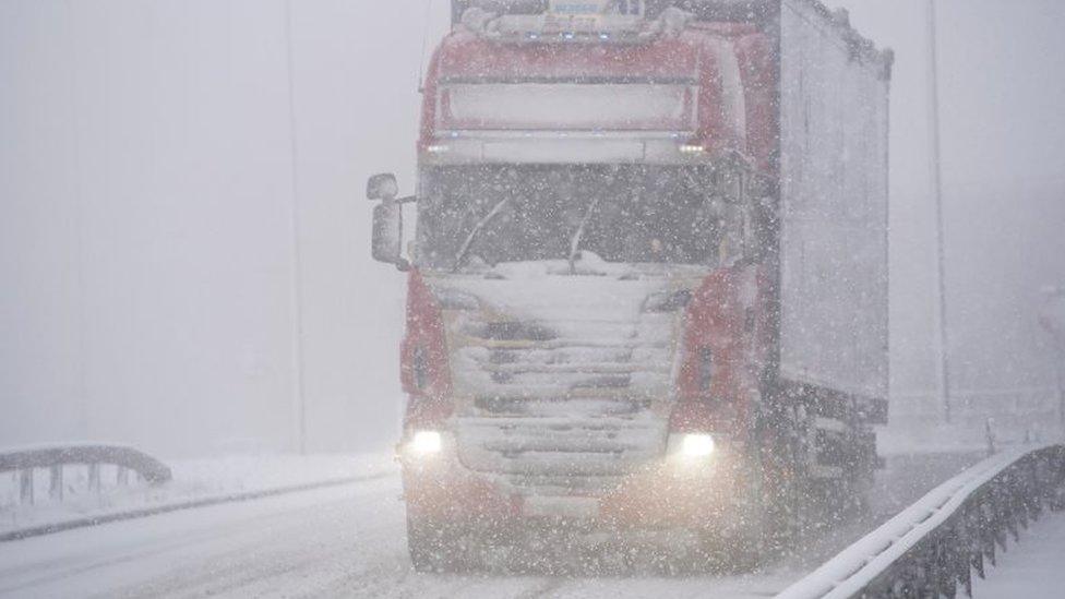 a HGV drives through snow on the M62 motorway