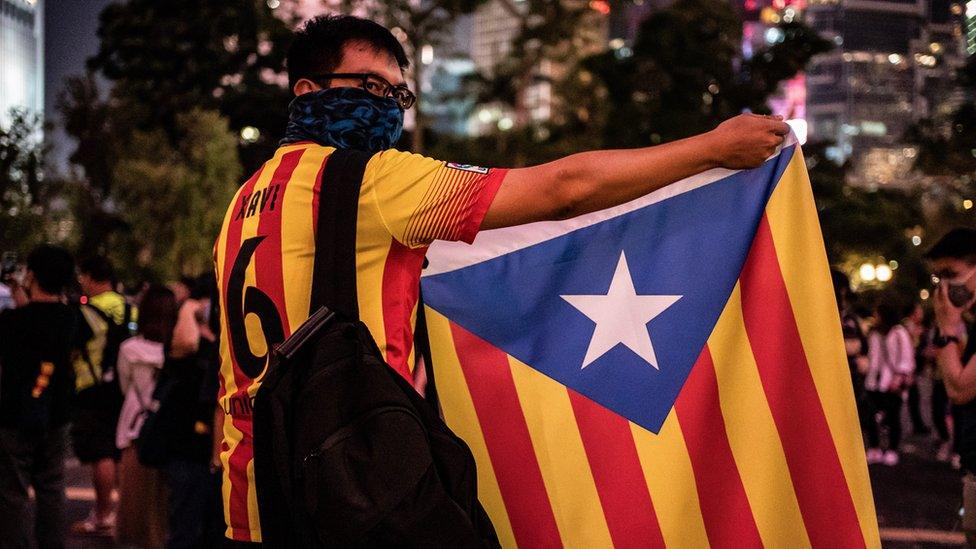 A protester in Hong Kong holds up a a Catalan pro-independence Estelada flag