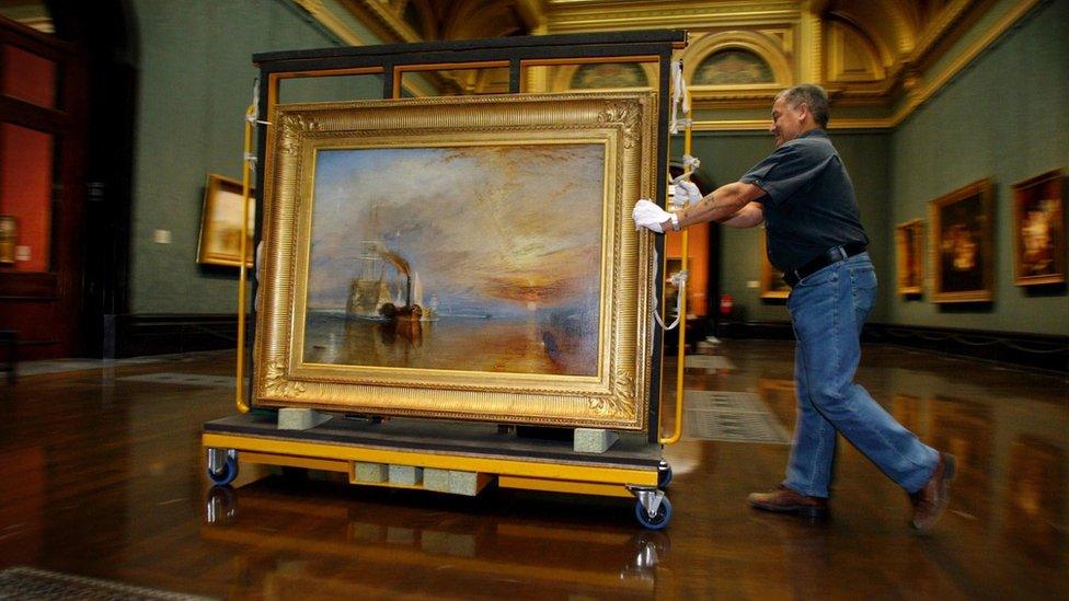 A National Gallery employee moving JMW Turner's 1839 work The Fighting Temeraire