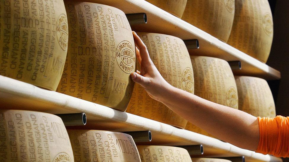 parmesan cheese stacked on shelves