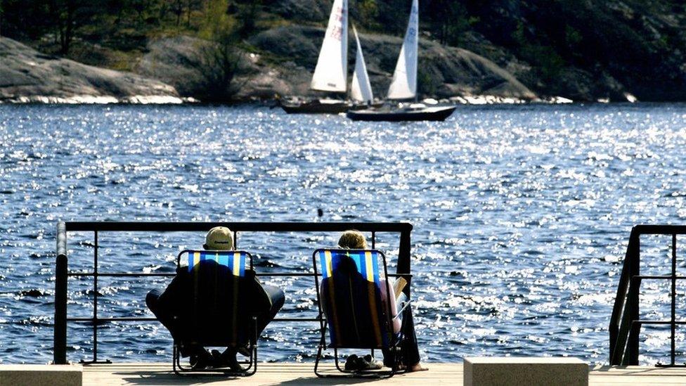 A Swedish couple on deck chairs overlooking the sea in Sweden