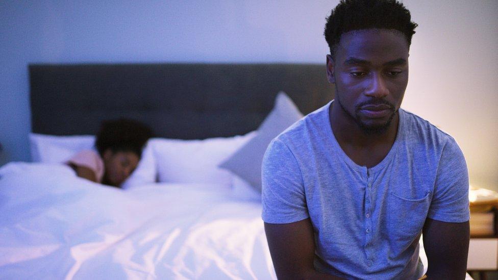 Insomnia stock image of man sitting up in bed