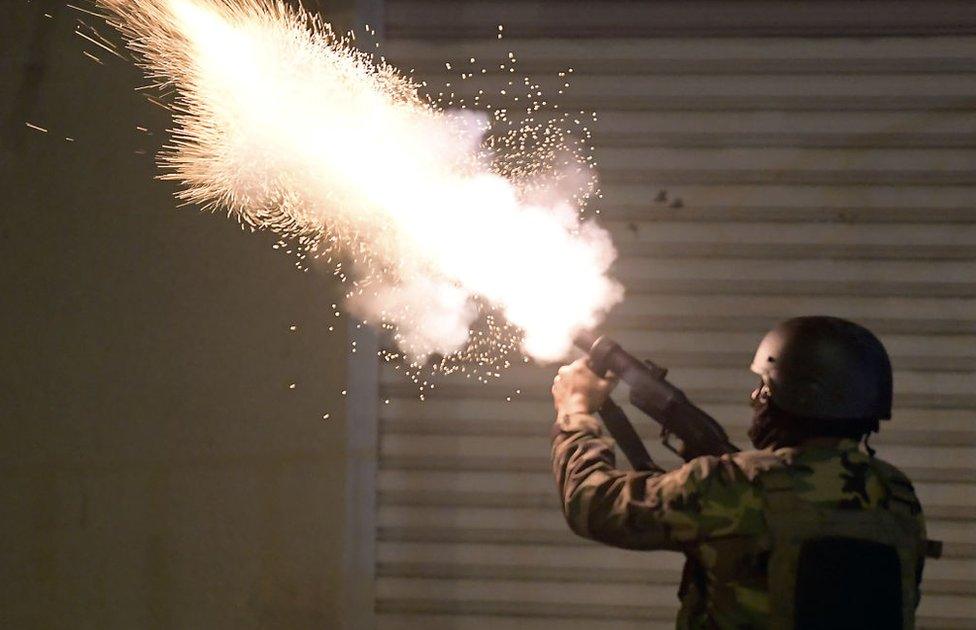 Tunisian security forces fire tear gas as protesters block a street in the Ettadhamen city suburb on the north-western outskirts of Tunis on January 18, 2021, amidst a wave of nightly protests in the North African country.