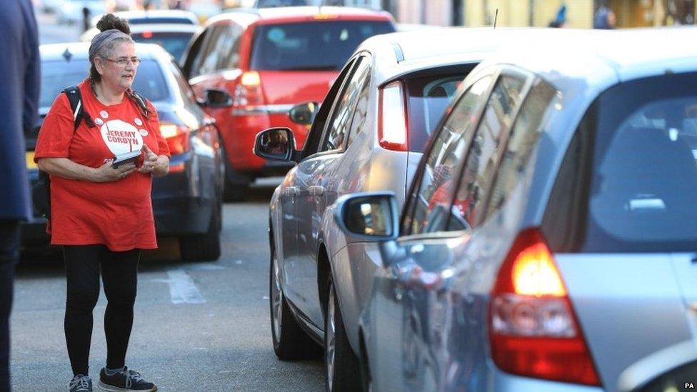 Woman handing out Jeremy Corbyn leaflets to motorists in London