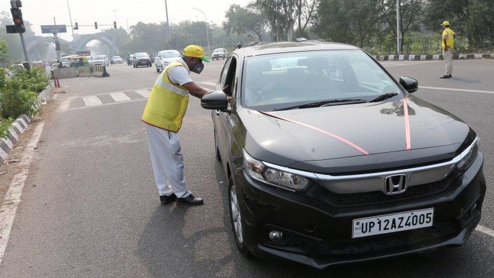 An odd number car is stopped by the civil defence volunteers during the first day of the implementation of the odd-even scheme